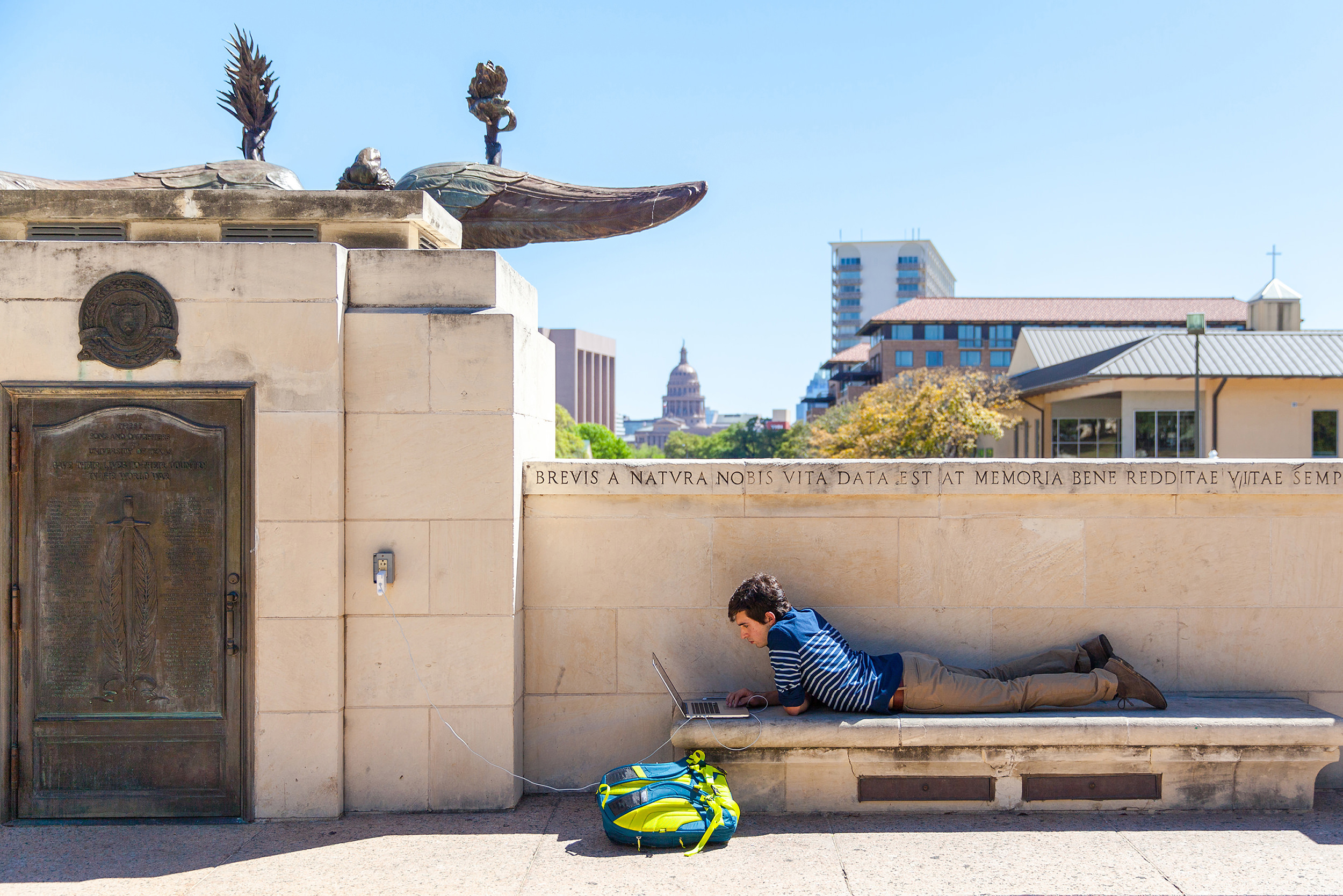 A student satudies on a laptop behind the Littlefield Fountain
